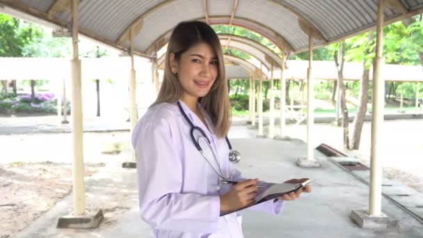 view of young female doctor with stethoscope standing outdoors  - Materiał filmowy, wideo