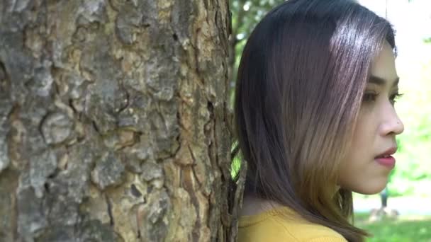 Beautiful thai sad woman spending time in park at daytime  - Filmagem, Vídeo
