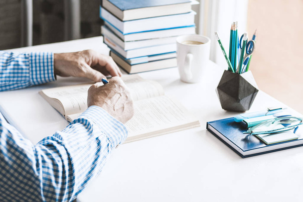 man in blue shirt reading book on modern stylish work place with - Φωτογραφία, εικόνα