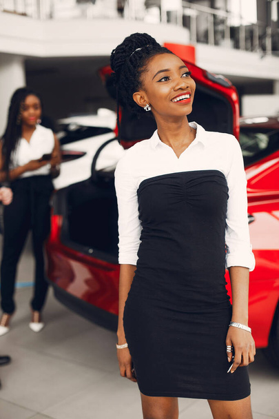 Two stylish black women in a car salon - Foto, imagen