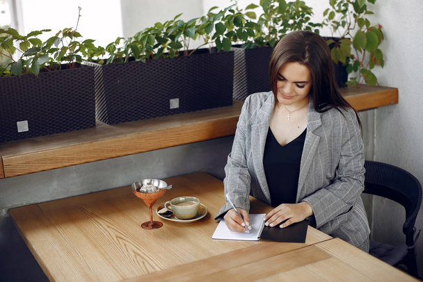 Бізнес-леді сидить за столом в кафе і працює
 - Фото, зображення