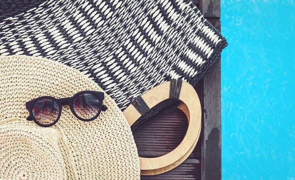 Vintage summer wicker straw beach bag, sun glasses, hat near swi - Fotografie, Obrázek