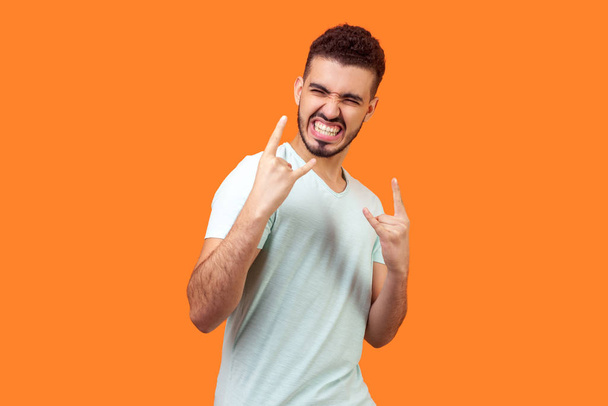 Portrait of excited crazy brunette man showing devil horns gestu - Zdjęcie, obraz