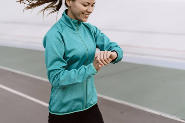 Jonge volwassen sportvrouw loopt op sport training in de stad - Foto, afbeelding