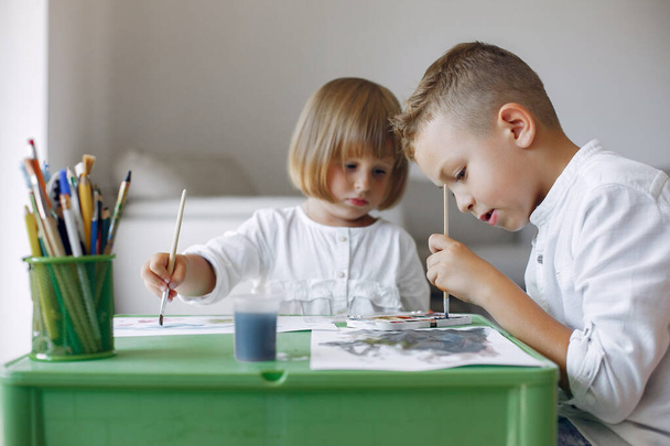 Children siting at the green table and drawing - Foto, imagen