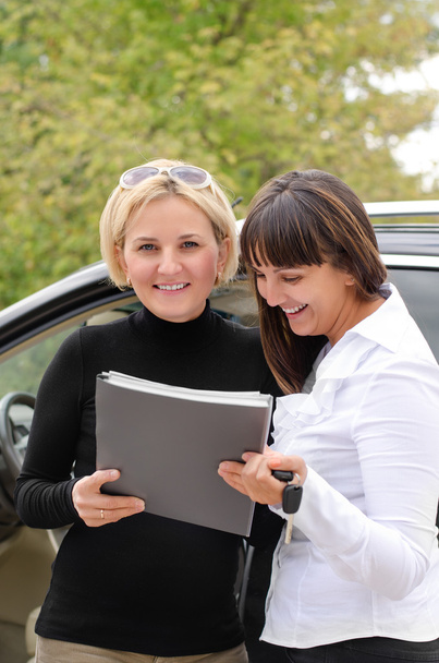 Two women signing a contract to buy a car - Photo, Image