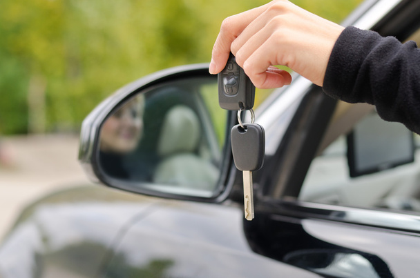 Mulher segurando chaves do carro fora do veículo
 - Foto, Imagem