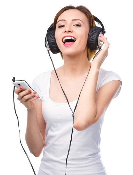 Young woman enjoying music using headphones - Foto, Bild