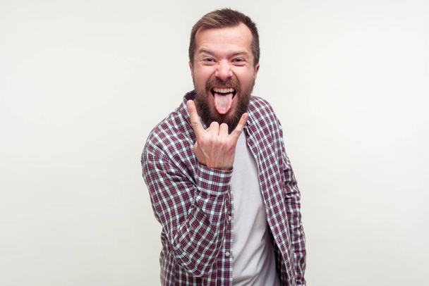 Portrait of crazy optimistic bearded man in plaid shirt showing  - Zdjęcie, obraz