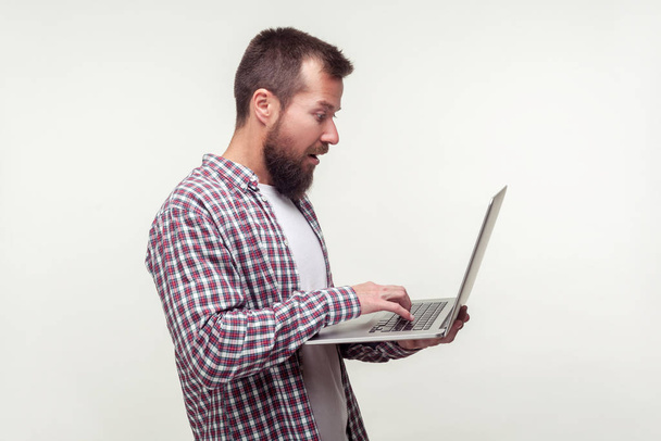 Portrait of surprised computer user, bearded man standing with l - Photo, image