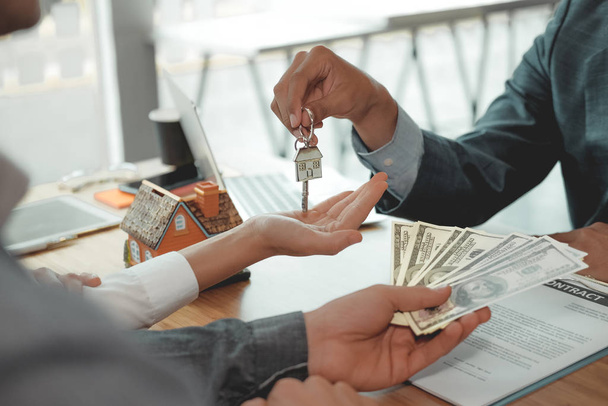 Μεσίτης που δίνει το κλειδί του σπιτιού σε ζευγάρι πελατών. πληρωμή πελάτη - Φωτογραφία, εικόνα
