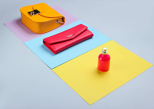 Minimalistische Mode. Modische Accessoires für Frauen auf pastellfarbenem Hintergrund. Ledergeldbörse, Gelber Sack, Parfümflasche. Seitenansicht - Foto, Bild