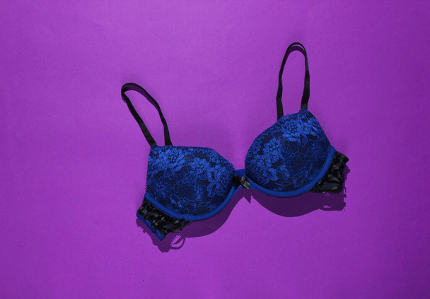 Сексуальный женский лифчик на фиолетовом фоне. Красивое нижнее белье. Вид сверху
 - Фото, изображение