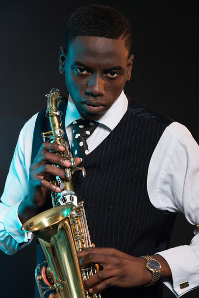retro Afryki amerykański muzyk jazzowy, trzymając jego saksofon. nosić - Zdjęcie, obraz
