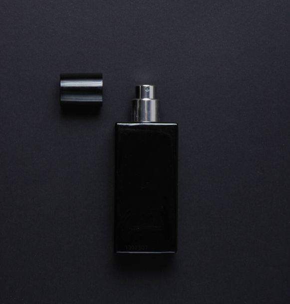 Bottle of male perfume on black background. Top view - Foto, imagen