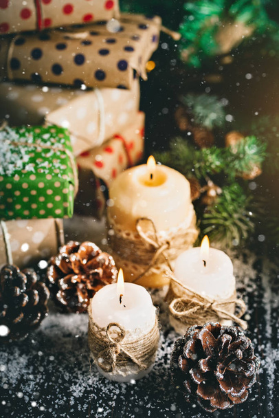 Καλά Χριστούγεννα και Ευτυχισμένο το νέο έτος. Κερί και χριστουγεννιάτικα παιχνίδια σε ένα ξύλινο τραπέζι. Bokeh. Επιλεκτική εστίαση. - Φωτογραφία, εικόνα
