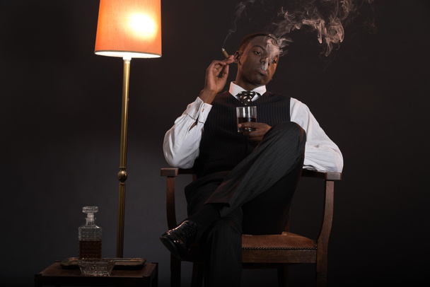 Retro afrikkalainen amerikkalainen gangsteri mies yllään raidallinen puku ja solmio
 - Valokuva, kuva