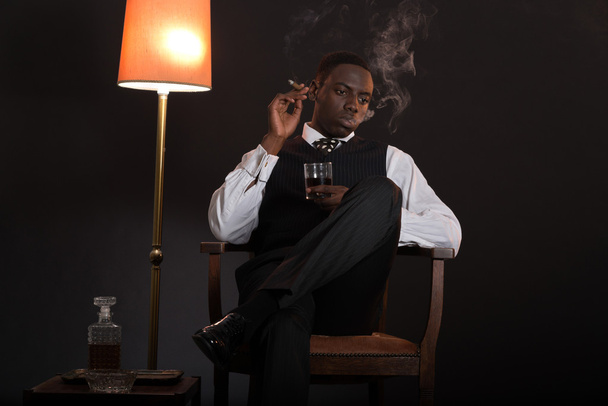 ρετρό αφρικανικός Αμερικανός γκάνγκστερ άνδρας ο οποίος φορούσε ριγέ κοστούμι και γραβάτα - Φωτογραφία, εικόνα