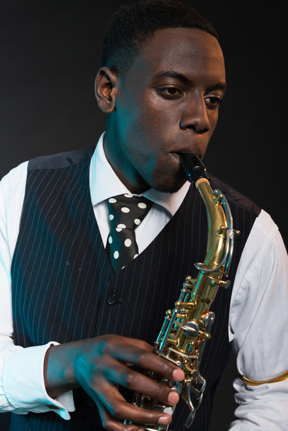 Retro Afro-Amerikaanse jazzmuzikant spelen op zijn saxofoon. w - Foto, afbeelding
