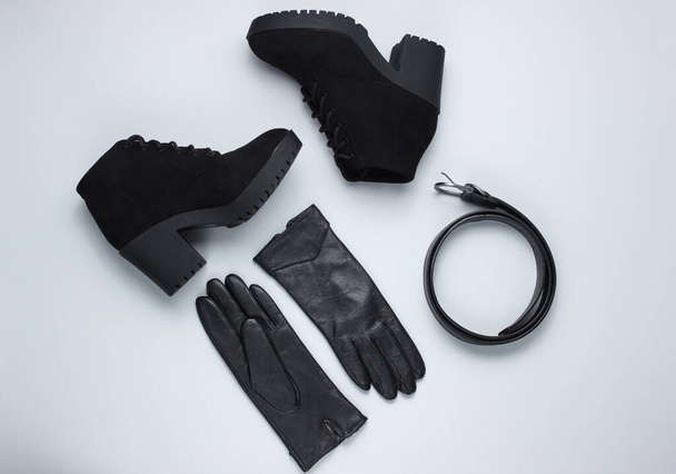 Fashionable women's shoes and accessories. Boots,  leather belt and gloves on gray background. Top view - Fotó, kép