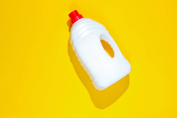 Бутылка геля для мытья на желтом фоне. Вид сверху
 - Фото, изображение