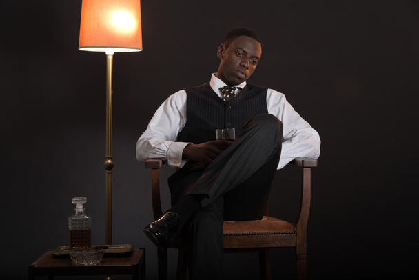 Retro afrikkalainen amerikkalainen gangsteri mies yllään raidallinen puku ja solmio
 - Valokuva, kuva