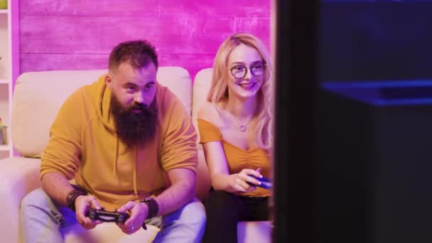 Όμορφη ξανθιά κοπέλα χαμογελά παίζοντας βιντεοπαιχνίδια - Πλάνα, βίντεο