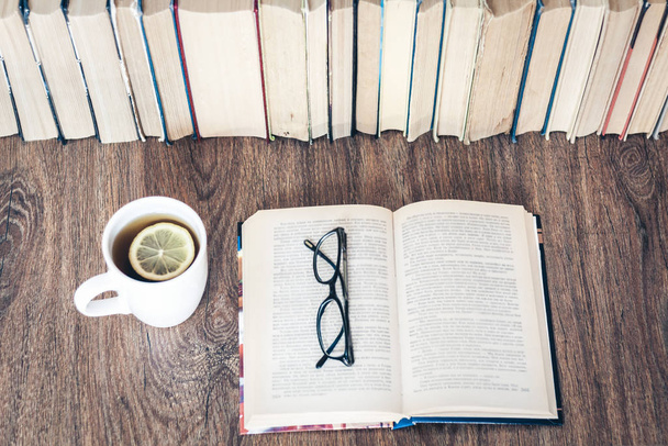 Stack of books education background, open book, glasses, and cup - Foto, Bild