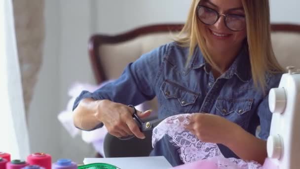 costureira loira no estúdio de costura trabalha com tecido na mesa
 - Filmagem, Vídeo