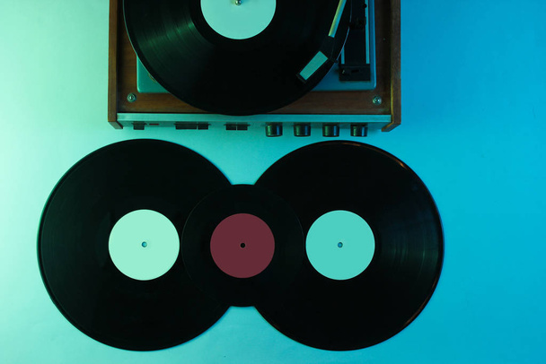 Retro vinyl record player. Vinyl records. Neon light, top view - Photo, Image