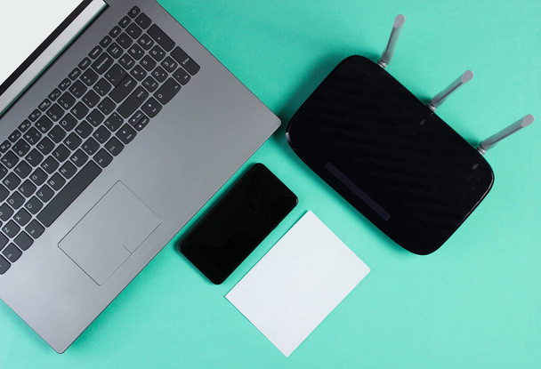 WLAN-Router, Smartphone, Laptop auf farbigem Hintergrund. weißer Kopierraum. moderne Gadgets. Ansicht von oben - Foto, Bild
