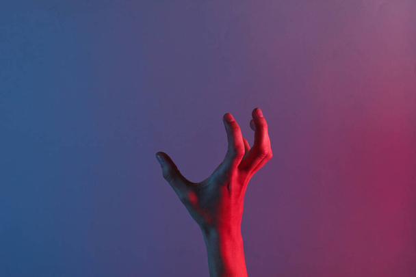 Mavi neon ışığı olan harika bir kadın eli. Cadılar Bayramı teması. Minimalizm modası. Sürrealizm. Sanat kavramı - Fotoğraf, Görsel