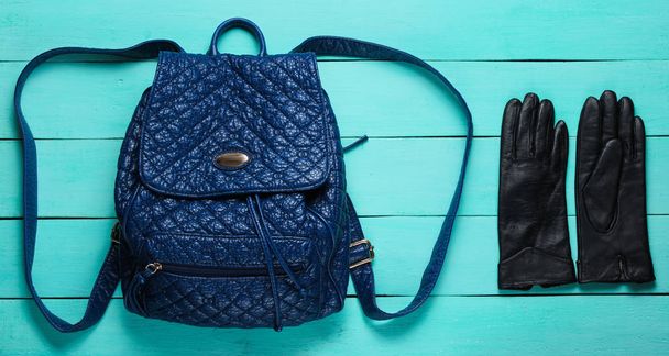 Leather fashionable backpack, gloves on blue wooden background. Trend accessories. Top view - Photo, Image