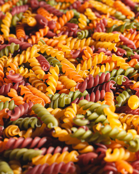 Uncooked tricolore fusilli pasta twist shapes background. Stock photo pasta twist shapes. - Photo, Image