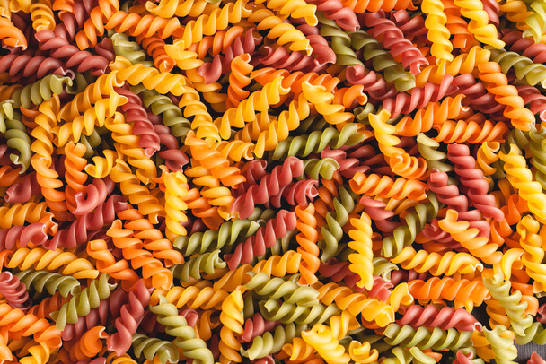 Uncooked tricolore fusilli pasta twist shapes background. Stock photo pasta twist shapes. - Photo, Image