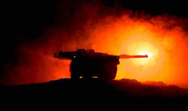 戦争の概念。夜間の戦争霧の空の背景に装甲車両のシルエット戦闘シーン。戦う準備ができているアメリカの戦車. - 写真・画像
