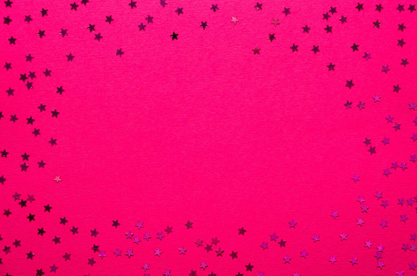 Confettis brillants en forme d'étoile sur fond rose chaud. Cadre festif avec espace de copie. Noël, fond abstrait de vacances, maquette. Couché plat, vue du dessus
 - Photo, image