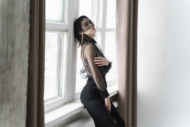 A beautiful Asian girl wearing trousers, a transparent blouse an - Фото, изображение