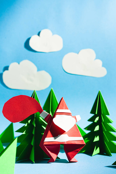 Origami Papai Noel com um saco de presentes. Cartão postal dos desenhos animados. Foto stock papel artesanal
. - Foto, Imagem