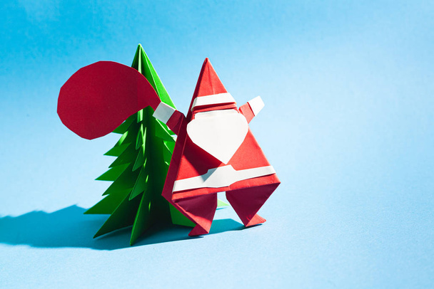 Origami kerstman met een zak cadeautjes. Cartoon ansichtkaart. Stockfoto handgeschept papier. - Foto, afbeelding
