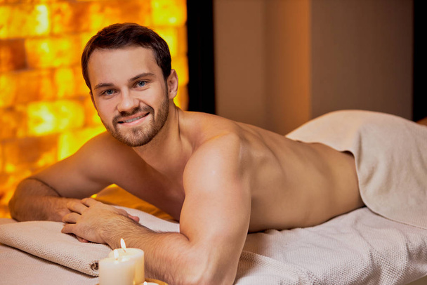 Handsome caucasian man lying on massage table at spa center - Photo, Image