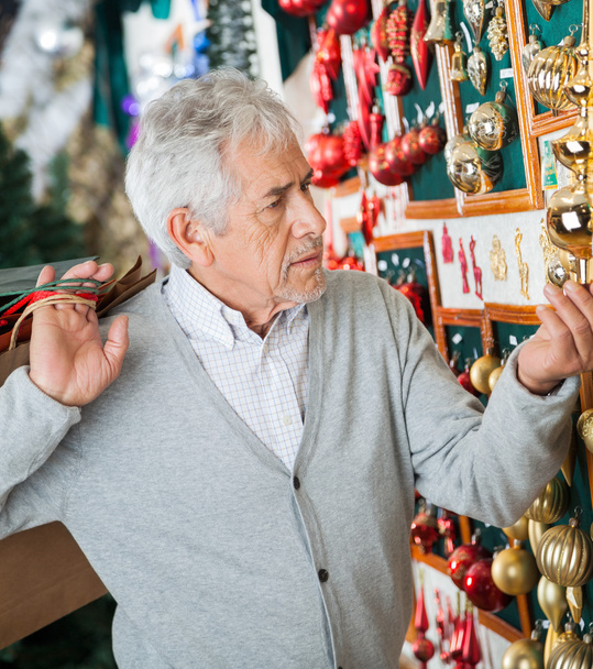 Man Buying Christmas Ornaments At Store - 写真・画像