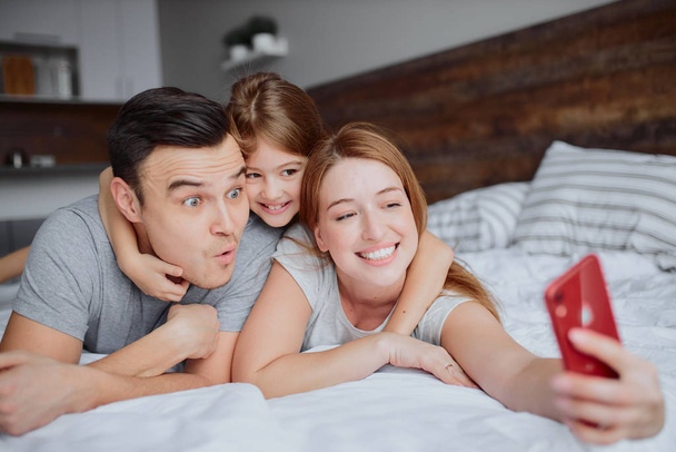 happy smiling family take selfie on bed - Photo, Image