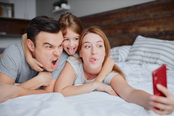 happy smiling family take selfie on bed - Фото, изображение