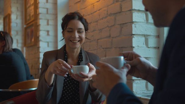 Liikekumppanit juovat kahvia ja juttelevat kahvilassa
 - Valokuva, kuva