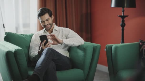 Young businessman looking mobile at luxury hotel. Business man relaxing phone - Video