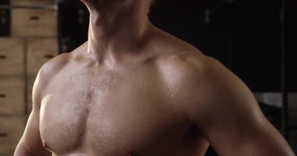 Front view close up of a shirtless athletic Caucasian man cross training at a gym recovering after an intensive work out, slow motion - Metraje, vídeo