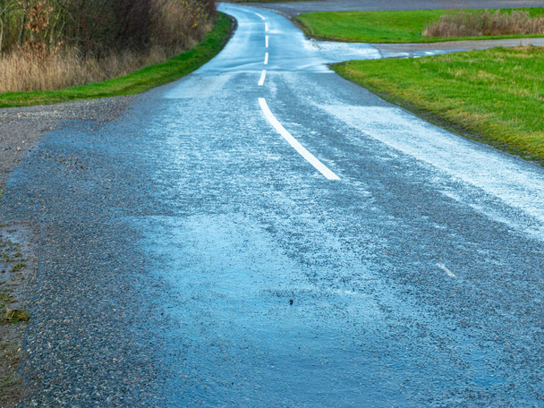 landschap met een natte asfaltweg - Foto, afbeelding