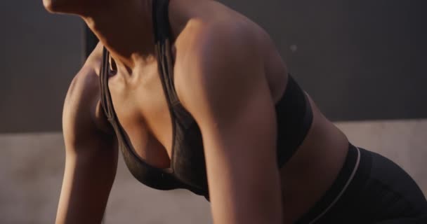 Side view close up of an athletic mixed race woman wearing sports clothes cross training at a gym, leaning forward and lifting weights on a barbell, slow motion - Filmmaterial, Video