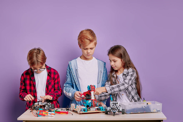 education, science, technology concept. caucasian children with electric toys and building robots - Foto, immagini